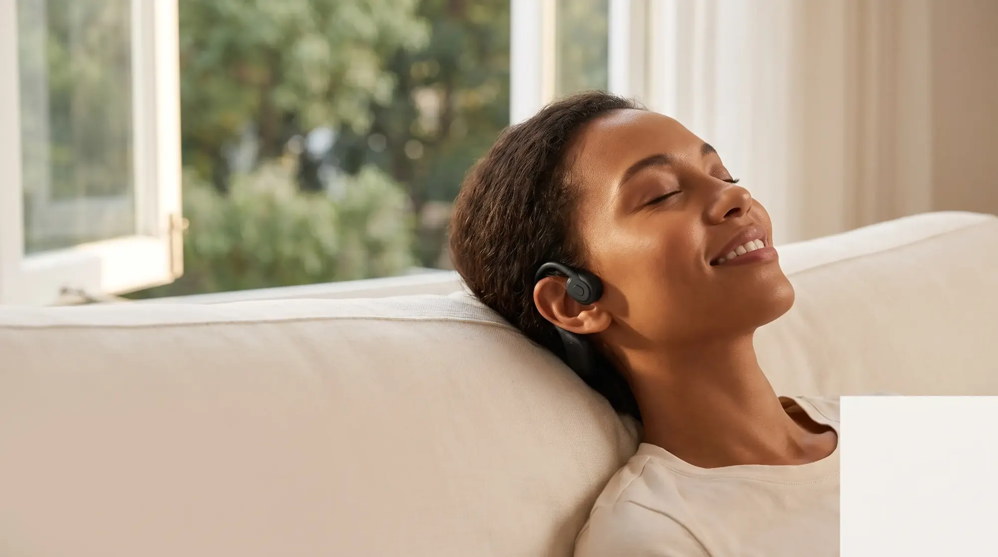 A woman relaxing with headphones in a sunlit room